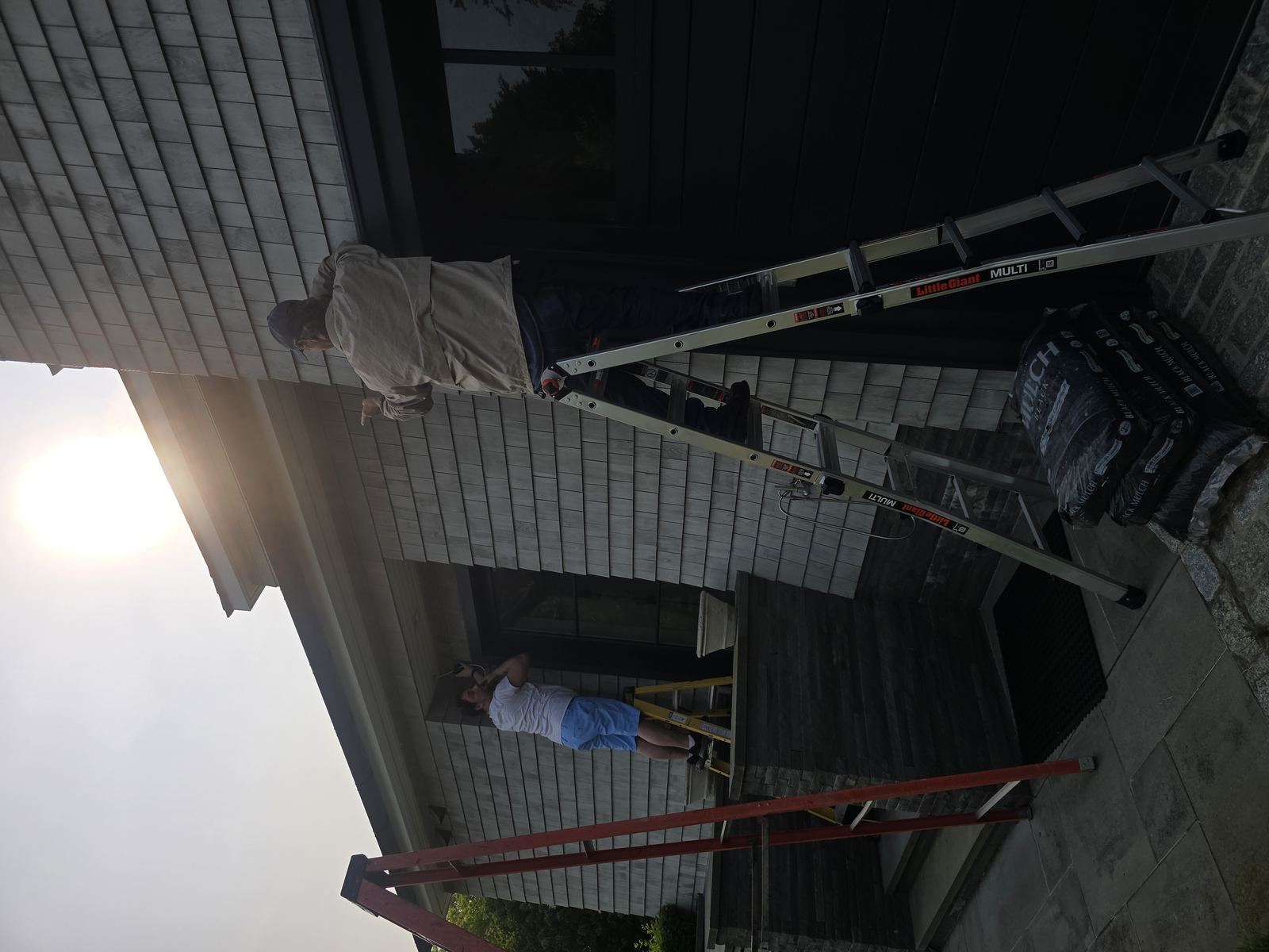 Technician installing security camera on exterior wall