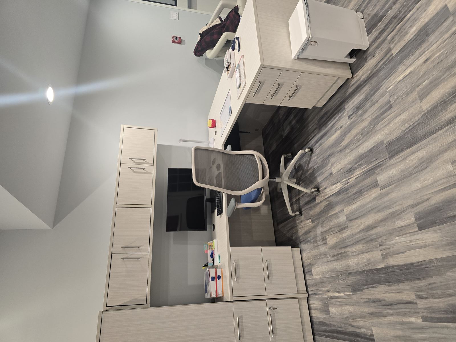 Finished office workstation with cabinetry and desk chair